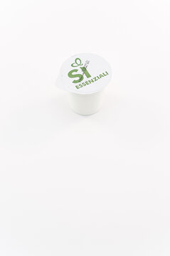 immagine editoriale illustrativa con confezione di yogurt naturale da produzione biologica su superficie bianca