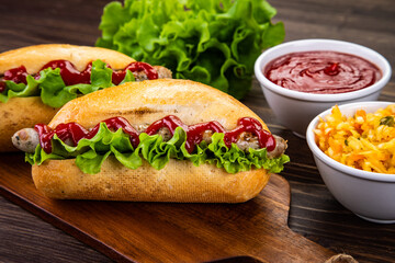 Hot dogs, coleslaw and ketchup on wooden table
