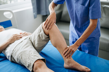 Close up of Physiotherapist working with patient on the bed.