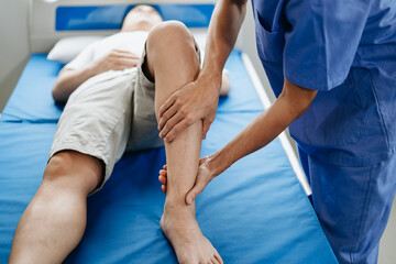 Obraz premium Close up of Physiotherapist working with patient on the bed.