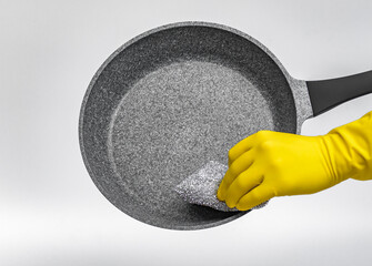 Mycie naczyń zmywakiem kuchennym w żółtych gumowych rękawiczkach na białym tle