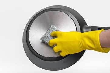 Sprzątaczka w żółtych gumowych rękawiczkach myje patelnię na białym tle