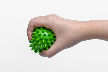 Zgniatanie zielonej piłki rehabilitacyjnej jako ćwiczenie po urazie dłoni 