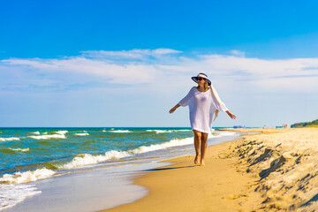 Fototapeta na wymiar Woman walking on sunny beach 