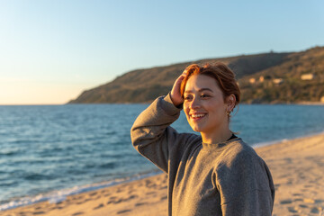redhead woman smiling on a beach