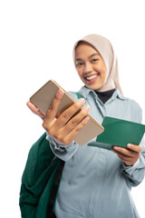portrait of smiling Asian Muslim woman showing smartphone and passbook on white background