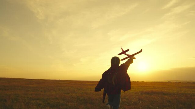 Dream girl hand wheat child light airplane fantasy teenager children silhouette becoming wants run pilot flying happy become park dreams run astronaut field sunset concept motion fun play toy kid