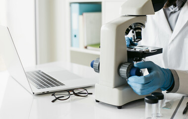 Medical laboratory, scientist hands using microscope for examining samples and liquid, Scientific and healthcare concept