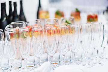 Stylish champagne glasses and food appetizers on table at wedding reception