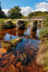 Fototapeta na wymiar Postbridge Clapper Bridge across East Dart River, Dartmoor, Devon, England