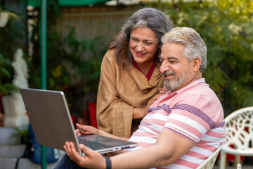 Indian senior couple using laptop. technology concept.