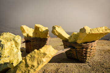 Heavy sulphur blocks carrying by the porters from the bottom of Kawah Ijen volcano caldera from...