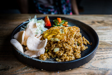Traditional indonesian cuisine nasi goreng (fried rice) with fried egg, chicken and kerupuk (shrimp crisps), Yogyakarta, Java, Indonesia