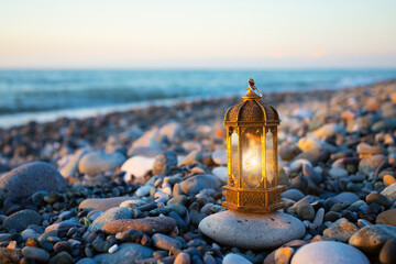 ramadan kareem, muslim lantern lamp glows on the seashore at sunset,copy space