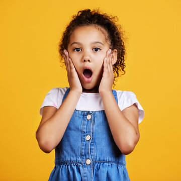 Portrait, wow and girl surprise, shock and kid amazed against a studio back ground. Face, young person and female child with facial expression, emoji and touching cheeks with news and announcement