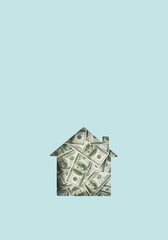 House shape cut out, filled with dollar bills, on blue background with copy space; Creative finance, pension, insurance, housing, wealth layout
