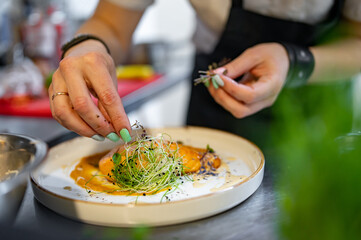 Chef cooking Roasted salmon steak with pumpkin cream on restaurant kitchen