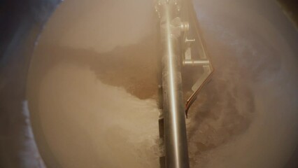 Huge steel brewing tank close-up.Beer in a whirlpool, mixed. Equipment at the brewery. Technological process of brewing.