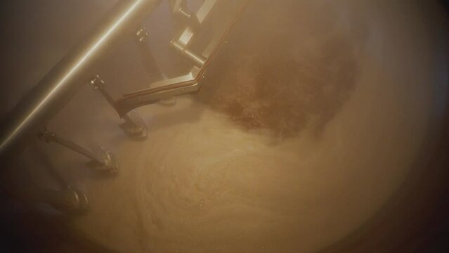 Huge steel brewing tank close-up.Beer in a whirlpool, mixed. Equipment at the brewery. Technological process of brewing.