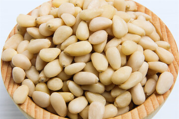Pine nuts in a wooden cup. Soft focus. Close-up.