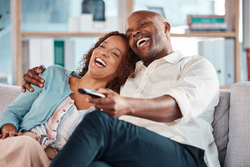 Couple, watching tv and laughing on sofa in home living room, bonding and hug. Interracial,...