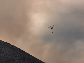 Firefighters helicopter putting out a fire. Arson forest fires in Asturias. Wildfires in Northern Spain
