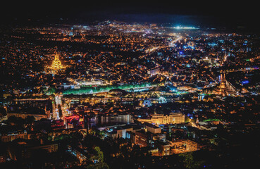 Majestic night view of Tbilisi, Georgia, with city lights twinkling amidst the unique blend of European and Asian architecture. - obrazy, fototapety, plakaty