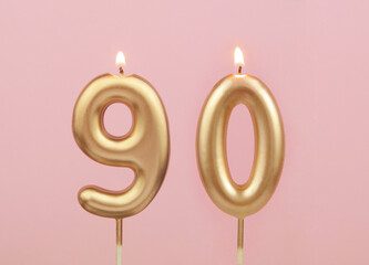 Gold birthday candles on pink background. Number 90.