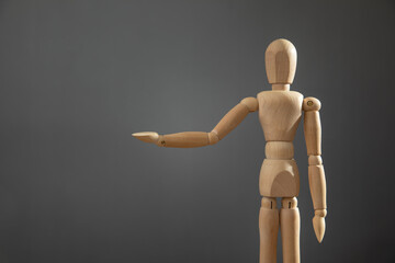 Wooden human figure on the grey background.