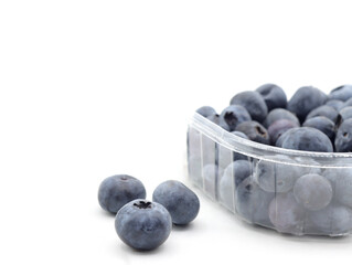  close up of blueberries in a clear plastic package on a white background