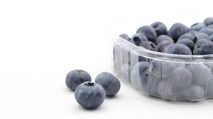  close up of blueberries in a clear plastic package on a white background