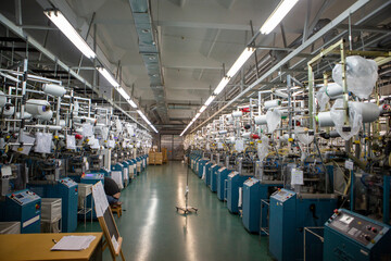 Textile industry with knitting machines in factory. Textile industry with a loom on the production...