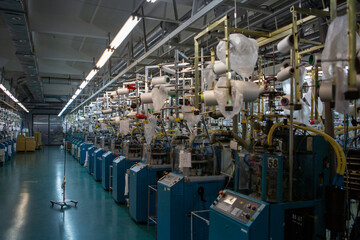 Textile industry with knitting machines in factory. Textile industry with a loom on the production of kapron tights.