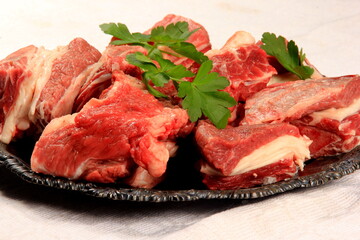 Raw beef ribs on wooden kitchen board, white background