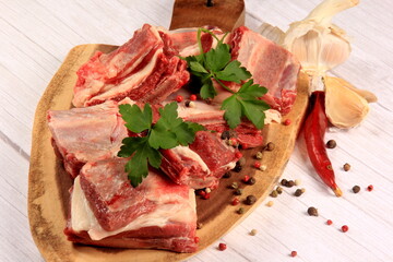 Raw beef ribs on wooden kitchen board, white background