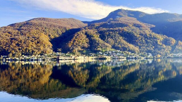 Mountain and Lake Lugano in Mirror Image a Sunny Day and Village Brusino Arsizio with Autumn Forest in Ticino, Switzerland.