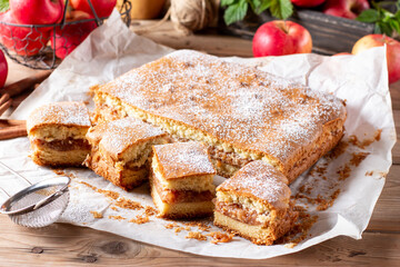 Homemade pie with apples and cinnamon on rustic wooden background