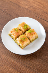 Turkish baklava with pistachio in plate.A plate baklava on wooden background,top view