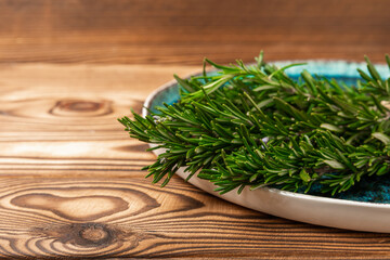 Fresh rosemary on brown texture background. Fresh spice herbs. Seasoning for meat and fish. Recipe.Organic bouquet of fresh rosemary on the table.Place for text. Copy space