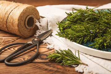 Fresh rosemary on brown texture background. Fresh spice herbs. Seasoning for meat and fish. Recipe.Organic bouquet of fresh rosemary on the table.Place for text. Copy space