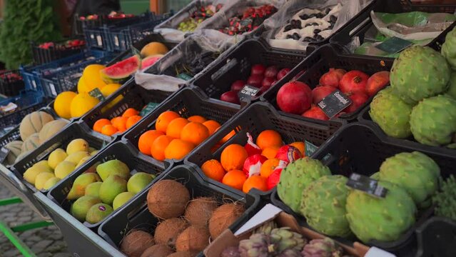 Viktualienmarkt in Munich, Germany. Fruit and vegetable stall at the market near the Marienplatz. Fresh exotic fruits for sale at the local outdoor market. Sales stands with fruits and vegetables. 