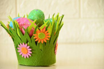 Colorful easter quail eggs in nest and tulips on pink background with . Flat lay. Spring composition. Happy easter greeting card. Copy space