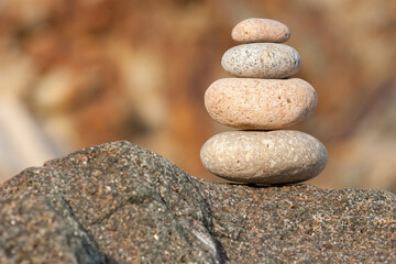 Fototapeta na wymiar A tower of stones. Zen like stones, Pyramides of stones. Zen stones. Peace buddhism meditation symbol. Relaxation