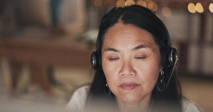 Call center, computer or face of Asian woman reading in telecom, customer services or crm communications company. Focus, senior or mature sales agent in headset at technical support office at night