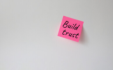 Build trust symbol. Pink steaky note with words Build trust. Beautiful white background. Business and Build trust concept. Copy space.