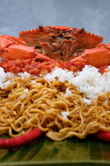 cooked crab on a white plate with rice and noodle 