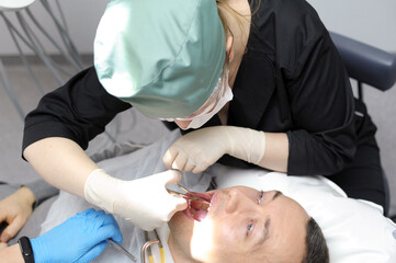 Obraz na płótnie Canvas remove teeth Dentist doctor works with a patient close-up. High quality photo