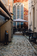 Quaint cafe tables and umbrella on cobbled side street in European city