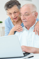elderly couple using a laptop
