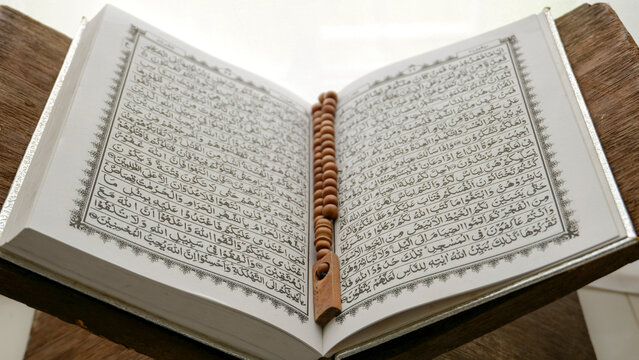 Conceptual image of religion. Holy tasbih or islamic prayer beads and Quran. Ramadan theme background